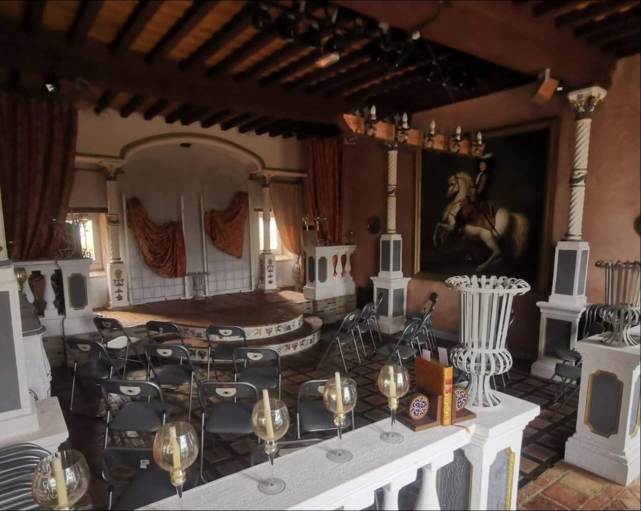 Salle du Château de Malvirade installée en configuration conférence, chaises face à la scène