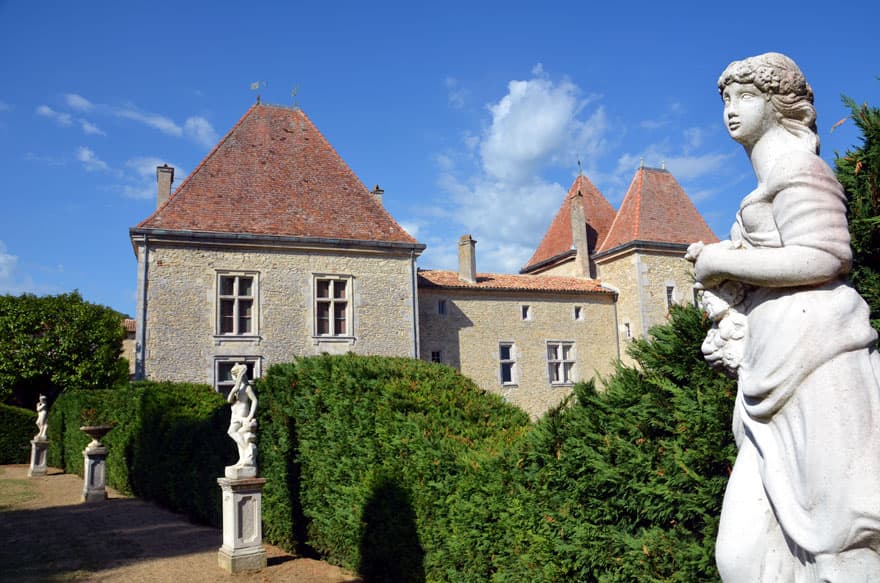 Perspective des jardins avec statue et façade du Château de Malvirade